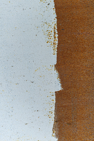 Rusted steel plate thinly covered in paint
